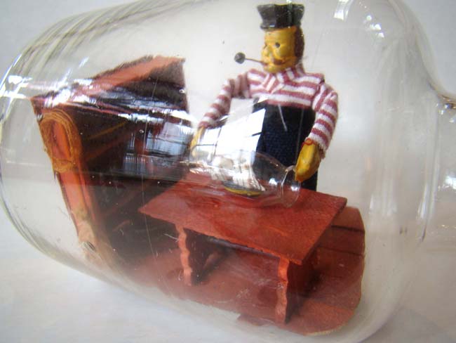 A wonderful small ship-in-a bottle depicting a sailor making a ship-in-a bottle — image 2